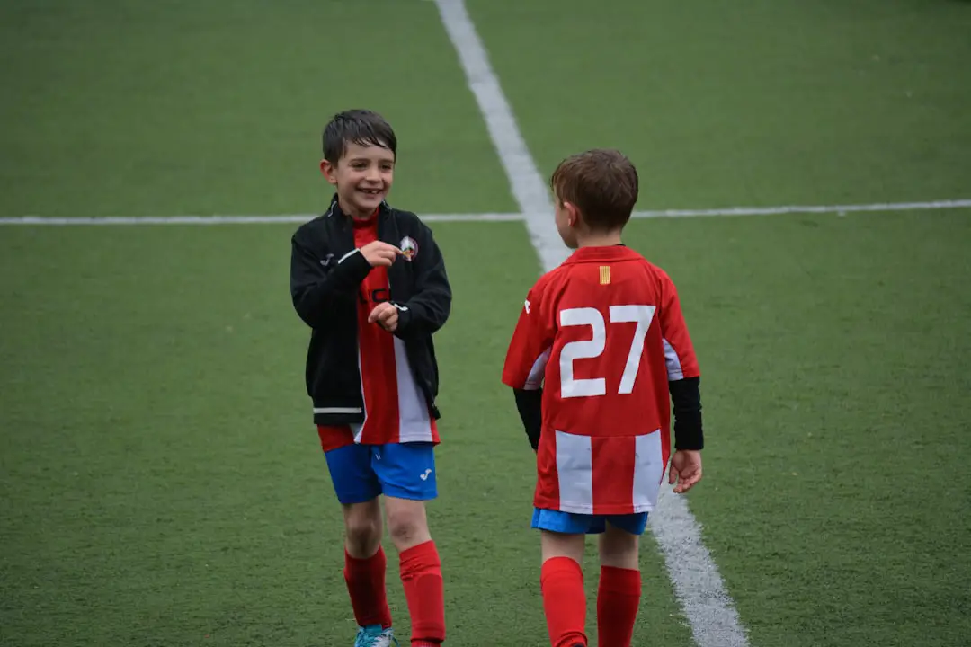 two boy standing on soccer field