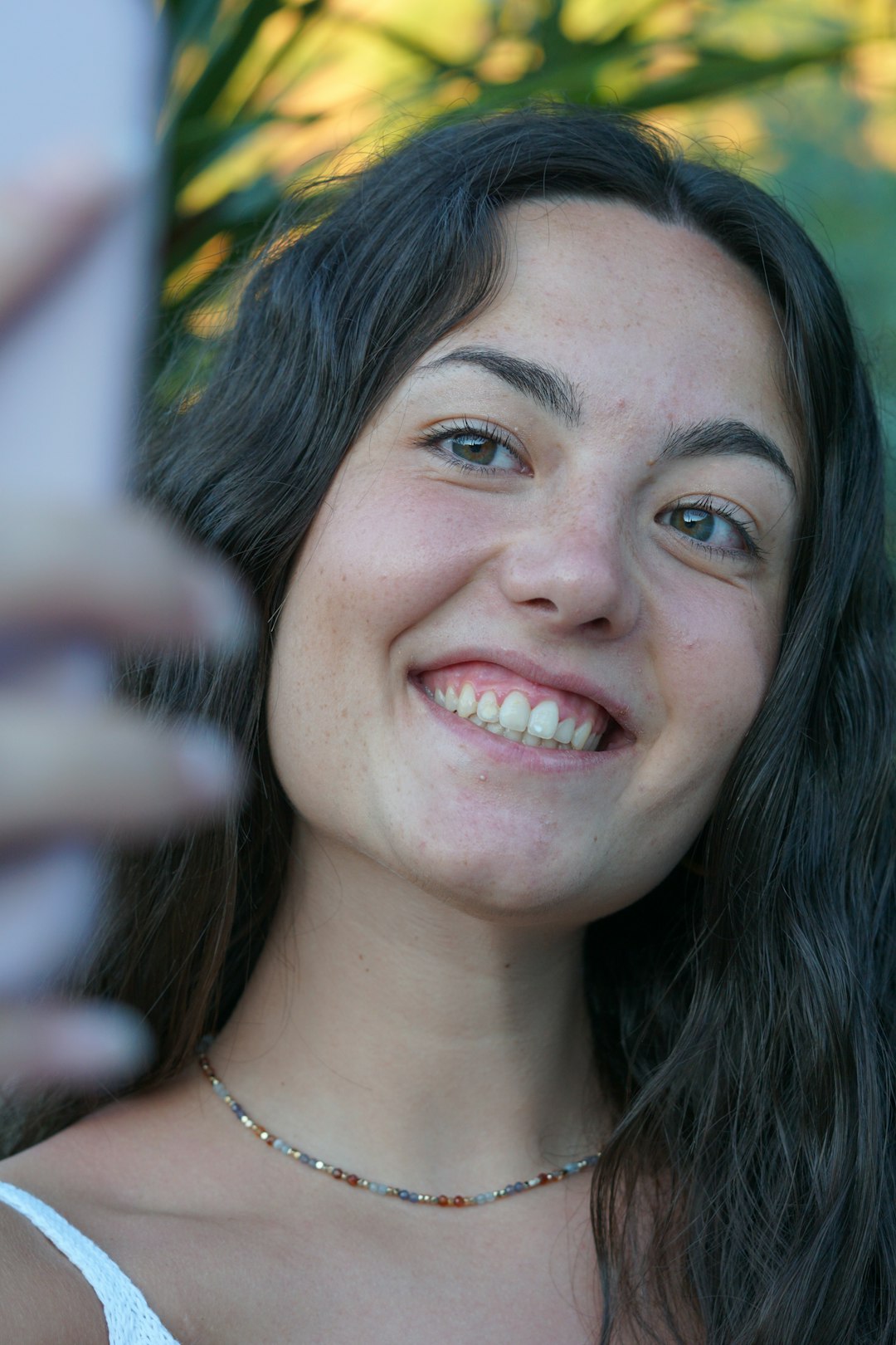 a woman is smiling and holding a cell phone
