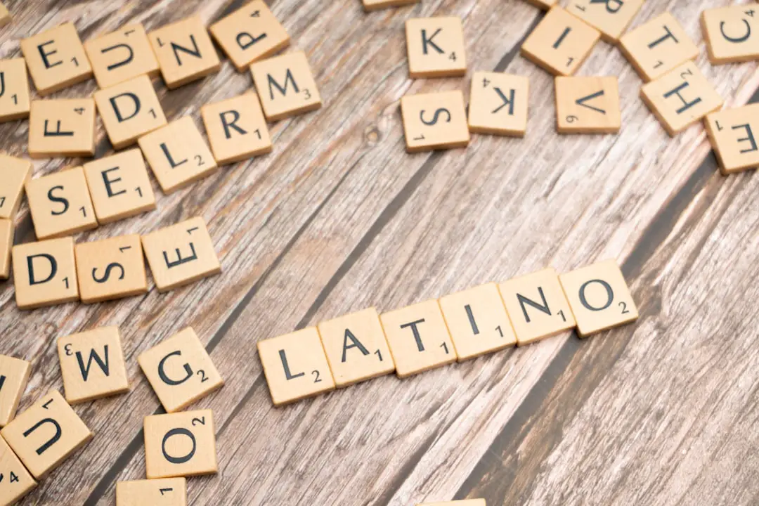 scrabble tiles spelling the word latin on a wooden surface