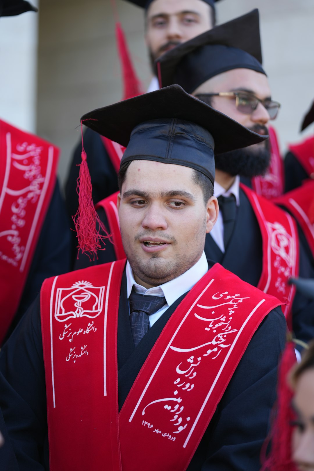 Graduates wearing caps and gowns are seen.